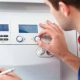 Plumber adjusting the knobs in the electric boiler.