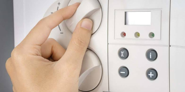 A woman opens and closes the hot water valve in combination boiler.